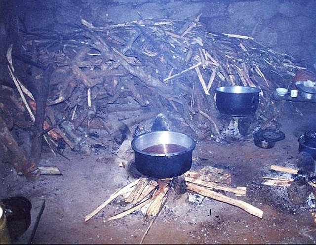 タンザニアで一般的な三ツ石カマドと山積みされた大量の薪